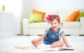 Happy child girl drawing with colored pencils lying on floor Royalty Free Stock Photo