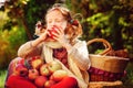 Happy child girl eating apples in autumn garden Royalty Free Stock Photo