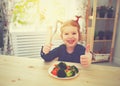 Happy child girl eating vegetables and showing thumbs up Royalty Free Stock Photo