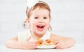 Happy child girl eats cookies and milk Royalty Free Stock Photo