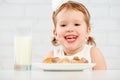 Happy child girl eats cookies and milk Royalty Free Stock Photo