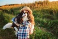 Happy child girl enjoying summer vacations with her dog, walking and playing on sunny meadow Royalty Free Stock Photo