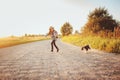 Happy child girl enjoying summer vacations with her dog, walking and playing on sunny meadow Royalty Free Stock Photo