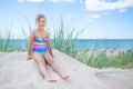 Happy child girl sitting on the beach