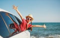 Happy child girl goes to summer travel trip in car Royalty Free Stock Photo