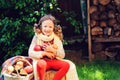 Happy child girl harvesting apples in autumn garden.