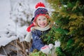 Happy child girl in hat with christmas ornament in winter garden Royalty Free Stock Photo