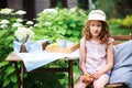 happy child girl in hat enjoying warm summer day in the blooming garden Royalty Free Stock Photo