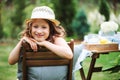 Happy child girl in hat enjoying warm summer day in the blooming garden Royalty Free Stock Photo