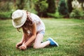 Happy child girl in hat enjoying warm summer day in the blooming garden Royalty Free Stock Photo