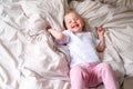 Happy child girl having fun jumping and playing funny active game in parents bed, Bouncing, fooling around, frolics Royalty Free Stock Photo