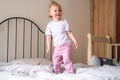 Happy child girl having fun jumping and playing funny active game in parents bed, Bouncing, fooling around, frolics Royalty Free Stock Photo