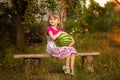 Happy child girl hold very big watermelon in sunny day