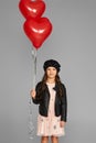 Happy child girl holding red heart shaped balloon Royalty Free Stock Photo