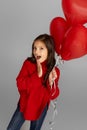 Happy child girl holding red heart shaped balloon Royalty Free Stock Photo