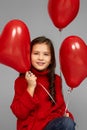 Happy child girl holding red heart shaped balloon Royalty Free Stock Photo