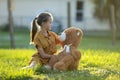 Happy child girl hugging her teddy bear friend outdoors on green grass lawn. Friendship concept Royalty Free Stock Photo