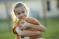 Happy child girl hugging her teddy bear friend outdoors on green grass lawn. Friendship concept Royalty Free Stock Photo