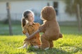 Happy child girl hugging her teddy bear friend outdoors on green grass lawn. Friendship concept Royalty Free Stock Photo