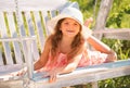 Happy child girl laughing and swinging on a swing at summer garden. Little girl having fun on a swing outdoor. Portrait Royalty Free Stock Photo