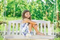 Happy child girl laughing and swinging on a swing at summer garden. Little girl having fun on a swing outdoor. Summer Royalty Free Stock Photo