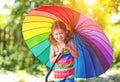 Happy child girl laughs and plays under summer rain with an umbrella. Royalty Free Stock Photo