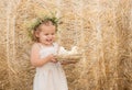 Happy child girl in linen dress smiling with fluffy baby chicks in nest.