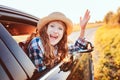 Happy child girl looking out the car window during road trip on summer vacations. Royalty Free Stock Photo