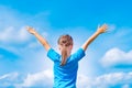 Happy child girl with open arms outdoor under blue sky. Young gi Royalty Free Stock Photo