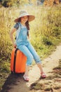 Happy child girl with orange suitcase traveling alone on summer vacation. Kid going to summer camp. Royalty Free Stock Photo