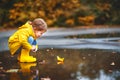 Happy child girl with paper boat in puddle in autumn on natu Royalty Free Stock Photo