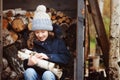 Happy child girl picking firewood from shed in winter Royalty Free Stock Photo