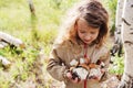 Happy child girl picking wild mushrooms on the walk in summer Royalty Free Stock Photo