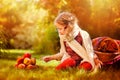 Happy child girl playing with apples in autumn garden Royalty Free Stock Photo