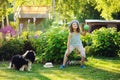 Happy child girl playing with her spaniel dog and throwing ball Royalty Free Stock Photo