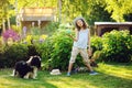 Happy child girl playing with her spaniel dog and throwing ball Royalty Free Stock Photo