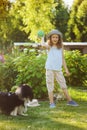 Happy child girl playing with her spaniel dog and throwing ball Royalty Free Stock Photo