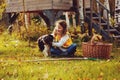 Happy child girl playing little gardener in autumn and picking leaves into basket. Seasonal garden work.