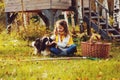 Happy child girl playing little gardener in autumn and picking leaves into basket. Seasonal garden work.