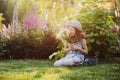 Happy child girl playing little gardener in summer, wearing funny hat and holding bouquet of flowers Royalty Free Stock Photo