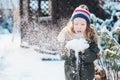 Happy child girl playing with snow on snowy winter walk on backyard Royalty Free Stock Photo