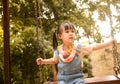Happy child girl playing swing outdoor in the park on summer time. Concept of Childhood happiness Royalty Free Stock Photo