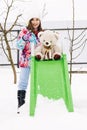 Happy child girl playing with teddy in the snow, winter time. Little toddler girl holding teddy bear, playing outdoors Royalty Free Stock Photo