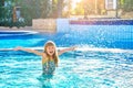 Happy child girl playing in the water and splashes water drop swimming pool. Summer vacation concept