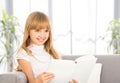 Happy child girl reading a book while sitting on sofa Royalty Free Stock Photo