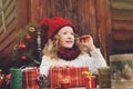 Happy child girl in red hat and scarf wrapping Christmas gifts at cozy country house, decorated for New Year and Christmas Royalty Free Stock Photo