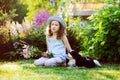 Happy child girl relaxing in summer garden with her spaniel dog Royalty Free Stock Photo