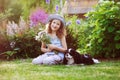 Happy child girl relaxing in summer garden with her spaniel dog Royalty Free Stock Photo