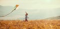 Happy child girl running with kite at sunset outdoors Royalty Free Stock Photo