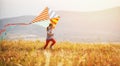 Happy child girl running with kite at sunset outdoors Royalty Free Stock Photo